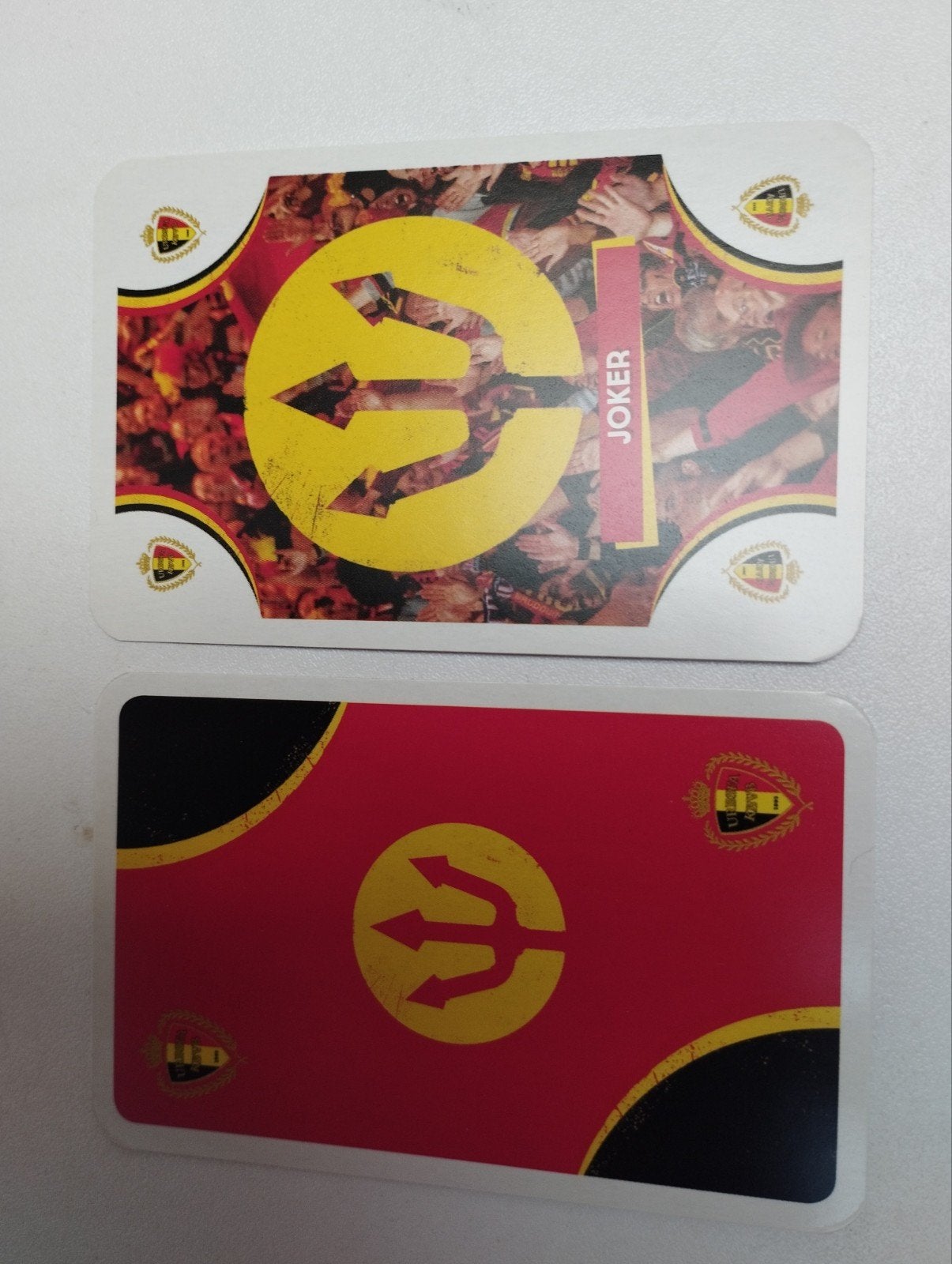 Een joker kaart in een vorm van de herk van de rode duivels, Ophalen