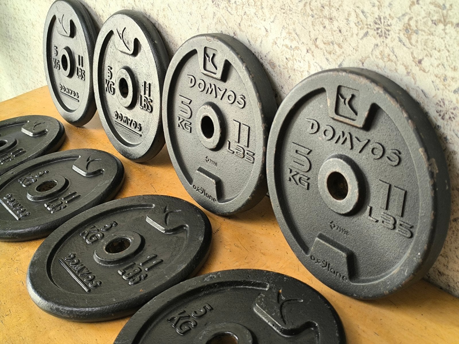 8 x Domyos 5kg plaques de musculation. 2,8cm., Enlèvement, Utilisé, Bras, Plaques d'haltères
