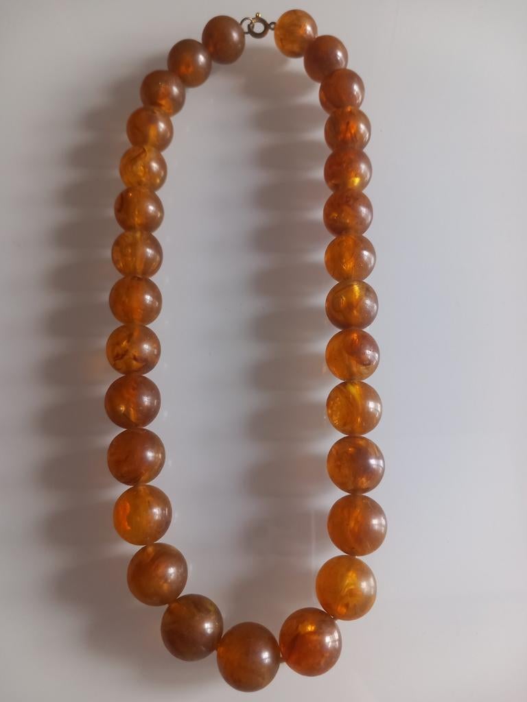 Collier en perles de bakélite de couleur ambre, Enlèvement