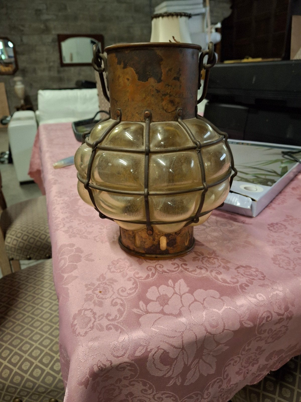 Antieke bolvormige scheepslamp in koper en een metalen kooi., Ophalen