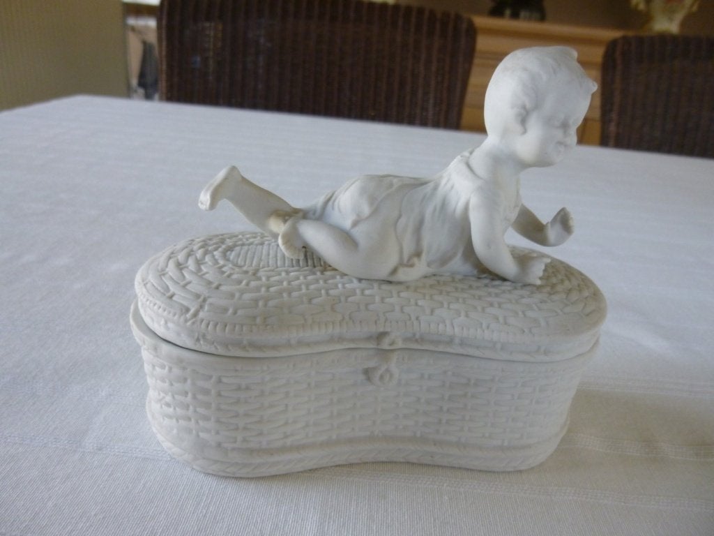 beeld in biscuit liggend kindje op mand, Ophalen of Verzenden