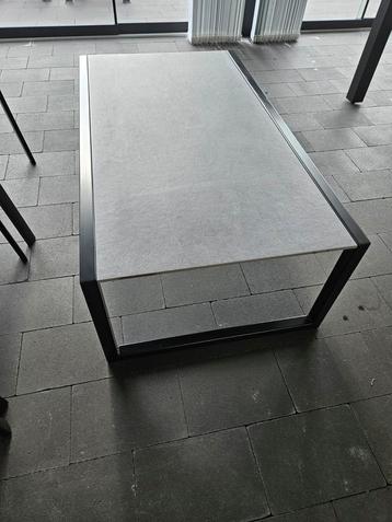 Table basse design noire avec carreaux de céramique.