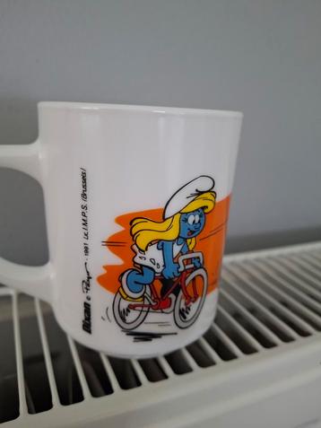 Mug Arcopal Schtroumpfs Schtroumpfette à vélo 1991 Dixan, Enlèvement ou Envoi, Comme neuf, Autres matériaux, Récipient(s)