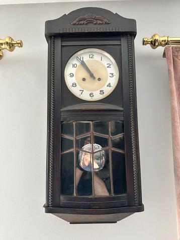 Werkende antieke wandklok beschikbaar voor biedingen