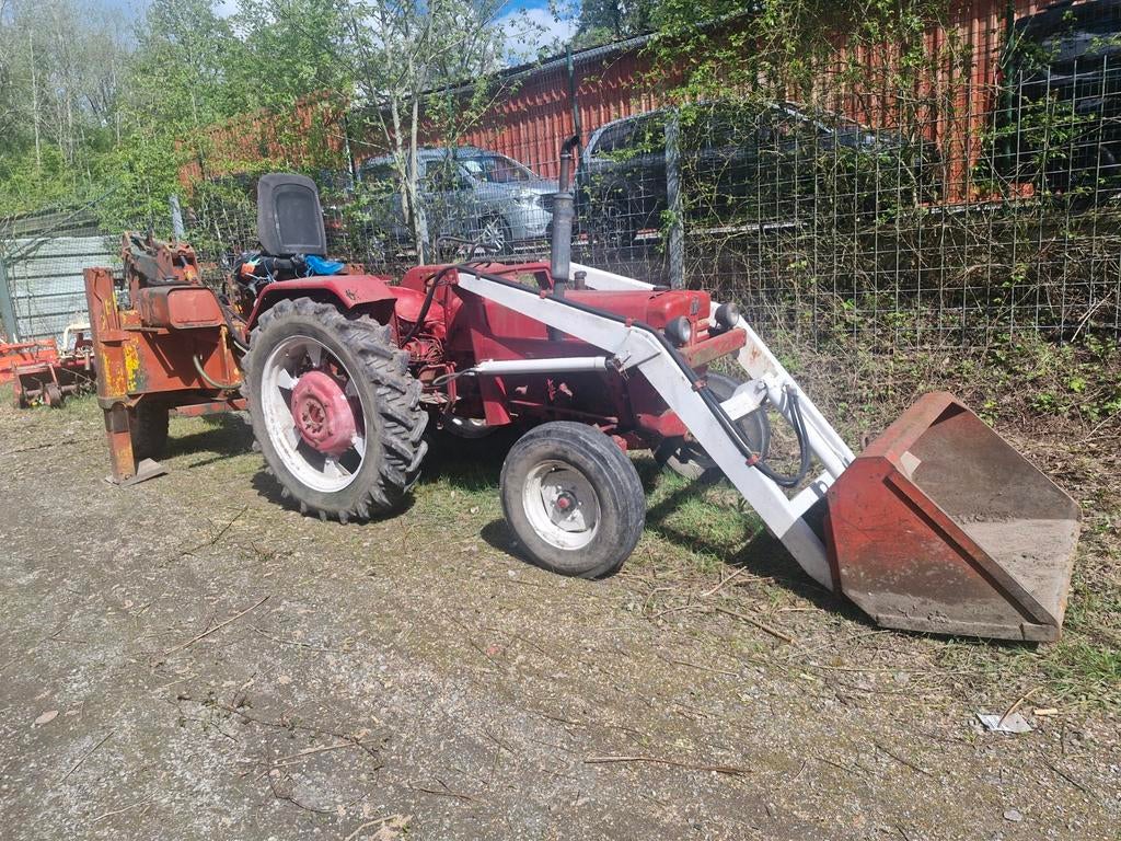 Tracteur avec chargeur avec papier et grue