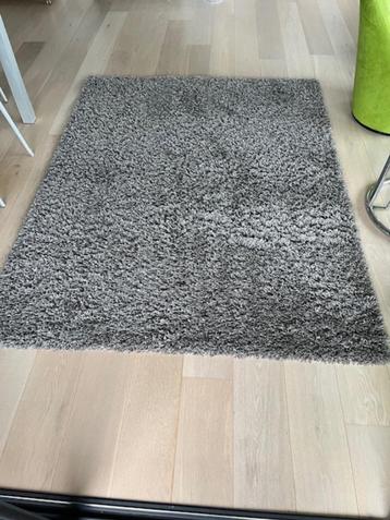 Hoogpolig grijs tapijt beschikbaar voor biedingen