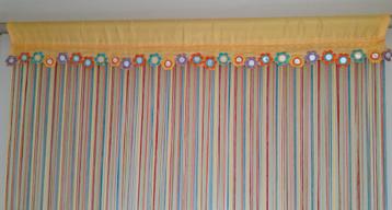 Kleurig lintjesgordijn met fleurige deco bovenaan. beschikbaar voor biedingen