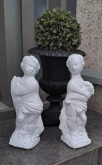 Koppel wit stenen tuinbeelden, een jongen en meisje. 