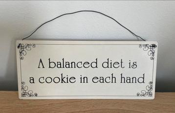 Metalen spreuk 'A balanced diet is a cookie in each hand'