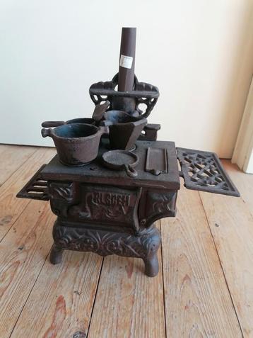 Miniatuur fornuis kachel gietijzer met attributen, Enlèvement