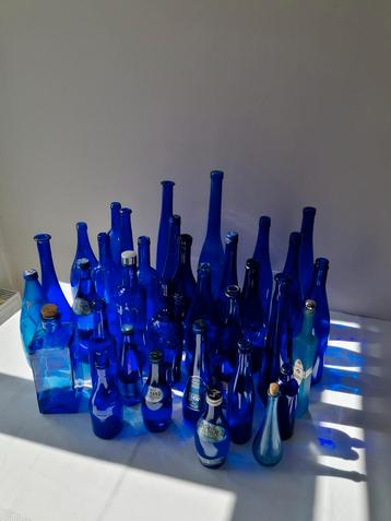 Grote partij van meer dan 30 blauwe glazen flessen 