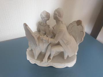 Vintage koekjesbeeldje man en vrouw op stoel beschikbaar voor biedingen