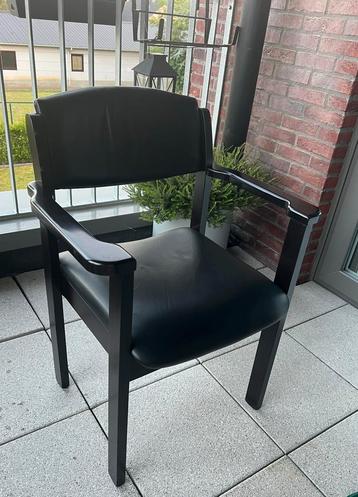 Zwarte stoelen met armleuningen beschikbaar voor biedingen