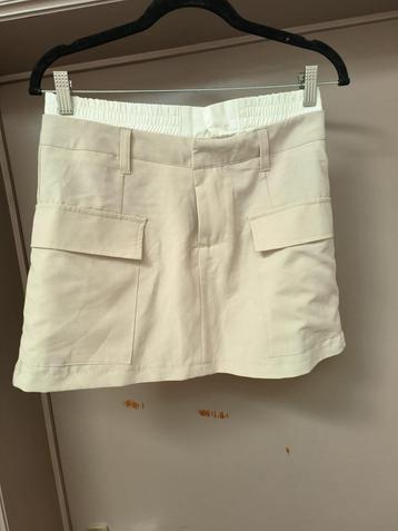Beige minirokje met witte rand beschikbaar voor biedingen