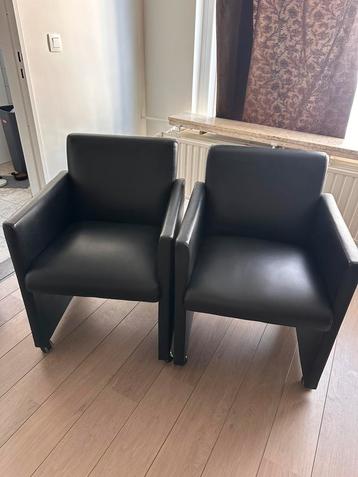 Twee zwarte leren fauteuils op wieltjes beschikbaar voor biedingen