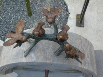 beeld van een vogel (5) in brons op een gepatineerde tak...