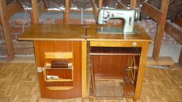 Zeer oude naaimachine met ondermeubel beschikbaar voor biedingen