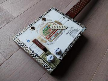 Elektrisch versterkte Cigar Box Guitar / gitaar + cursusboek beschikbaar voor biedingen