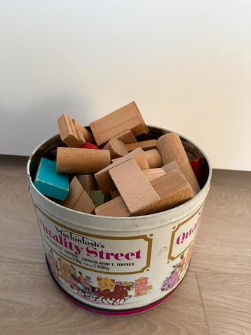 Blikken doos vol houten bouwblokken beschikbaar voor biedingen