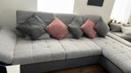 Grand canapé en tissu gris et gris foncé.