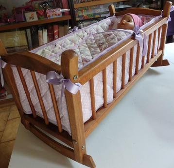 Berceau-bascule en bois ciré, entièrement garni , avec bébé