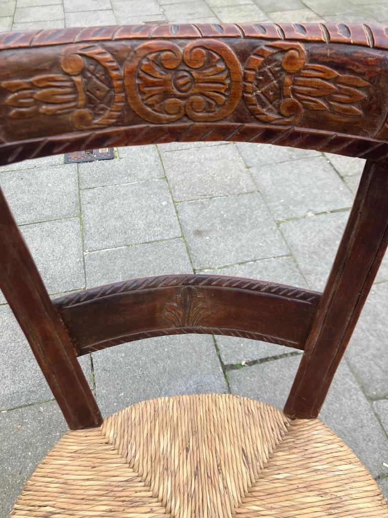 Chaise paillée en noyer, richement sculptée au décor antique, Enlèvement
