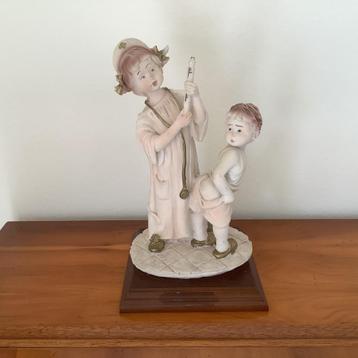 STATUE D'UNE INFIRMIÈRE AVEC UN BÉBÉ.