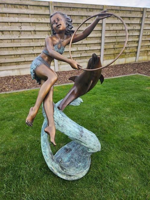 BRONZEN MEISJE MET DOFIJN LAASTE STUK AAN 1650 IPV 2475 EURO, Tuin en Terras, Tuinbeelden, Nieuw, Mensenbeeld, Overige materialen