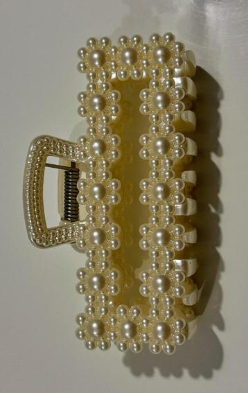 Witte haarknijper met bloemen beschikbaar voor biedingen