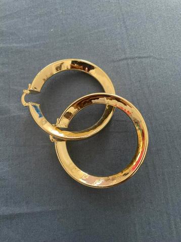 Gouden oorringen — glanzende look beschikbaar voor biedingen
