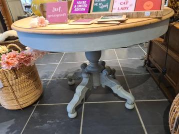 Opgemaakte oude ronde tafel met centrale poot beschikbaar voor biedingen