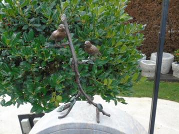 bronzen vogel (2) op een hoge tak. beschikbaar voor biedingen