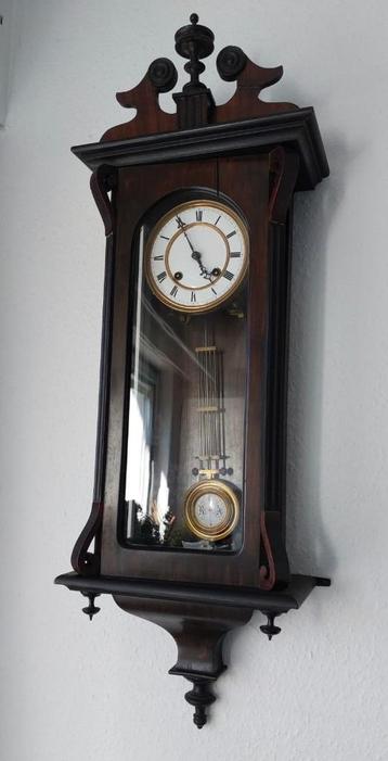 Wandklok met slinger  lengte = 85 cm breedte = 30 cm diepte  beschikbaar voor biedingen