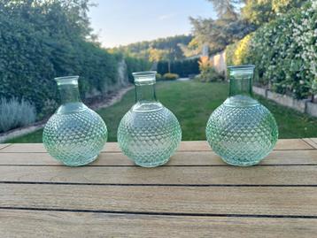 Vaasjes groen glas beschikbaar voor biedingen