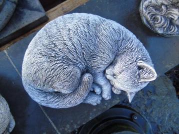Standbeeld van een kat liggend in een gepatineerde stenen ba