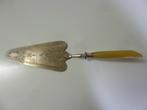 1 pelle à tarte argentée gravée - manche style corne jaune, Ophalen