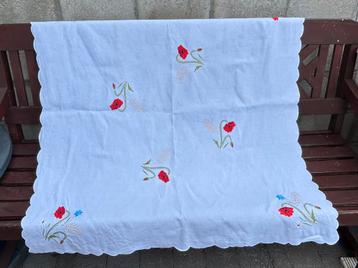 Wit tafelkleedje met geborduurde bloemen. beschikbaar voor biedingen