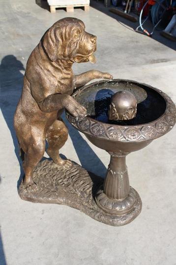 Hond op een bronzen fonteinbak, waterstraal. beschikbaar voor biedingen