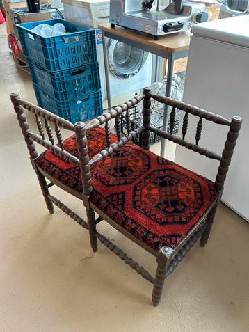 Antieke spijlenbank met rood-zwart beschikbaar voor biedingen