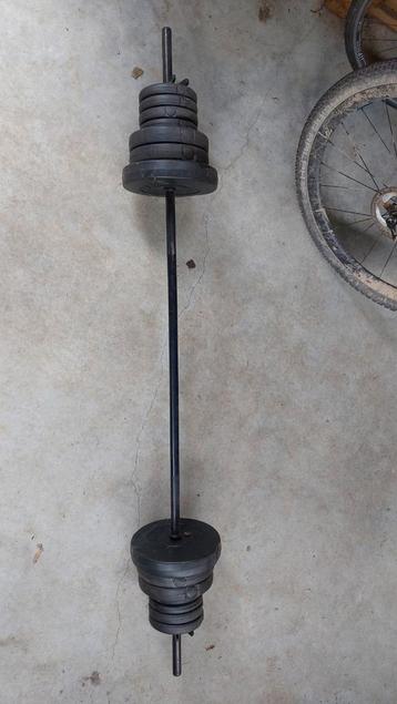 Lang gewicht (barbell) met vele gewichtjes  beschikbaar voor biedingen