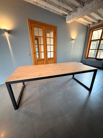 Grote houten tafel met zwarte stalen poten beschikbaar voor biedingen