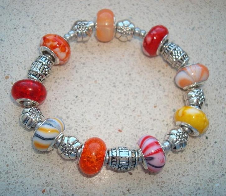 Elastische armband met bedels in oranje-geel, Handtassen en Accessoires, Armbanden, Nieuw, Elastiek, Overige kleuren, Met bedels of kralen