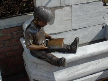 Standbeeld van een zittende jongen die een bronzen boek lees beschikbaar voor biedingen