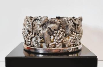 Verzilverde wijnfleshouder met druivenranken. beschikbaar voor biedingen