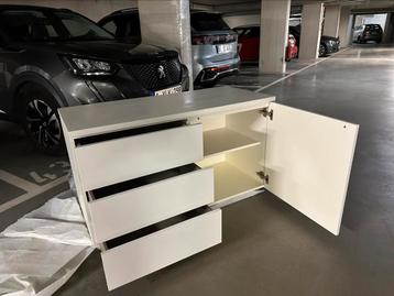 Moderne witte opbergkast met lades en plank beschikbaar voor biedingen