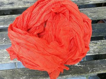 Oranje sjaal in lichte stof.