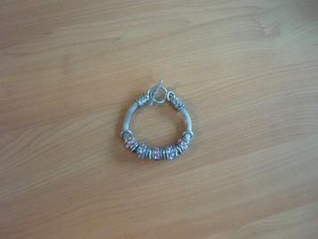 Zilverkleurige dikke armband ringen en roze paarse bollen beschikbaar voor biedingen