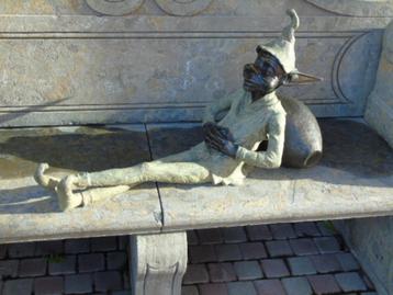 statue d un lutin ou troll en bronze endormi sur une cruche
