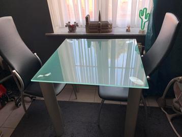 Glazen tafel met 2 stoelen beschikbaar voor biedingen