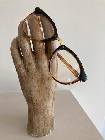 Hand met vintage bril beschikbaar voor biedingen
